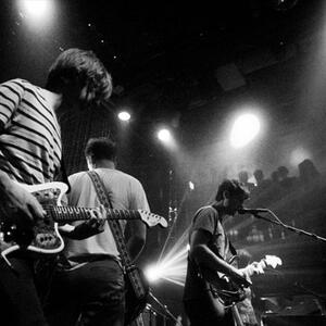 A black and white photo of the Swirlies performing live.