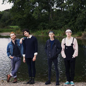 Bears in Trees (the band) stand together in front of a river.