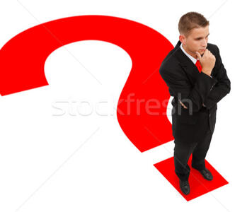 A man stands at the end of a big red question mark, looking puzzled.
